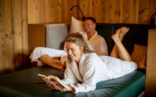 Paar in Bademänteln auf Entspannunglounge 