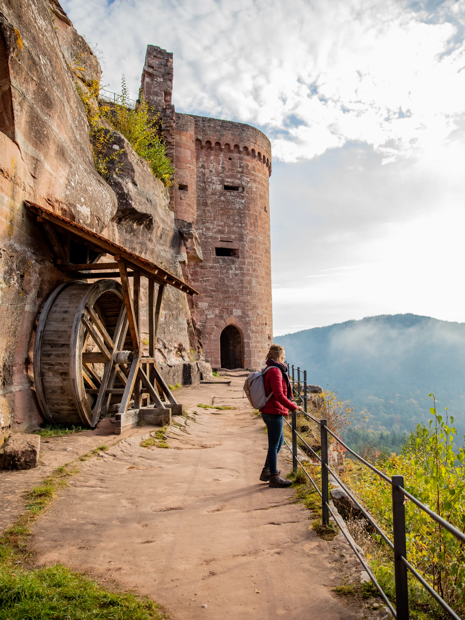 Pfalzblick Wald Spa Resort: Ihr Naturhotel in Rheinland-Pfalz Frau mit Rucksack blickt von Burgmauer auf bewaldete Berge und Wolken
