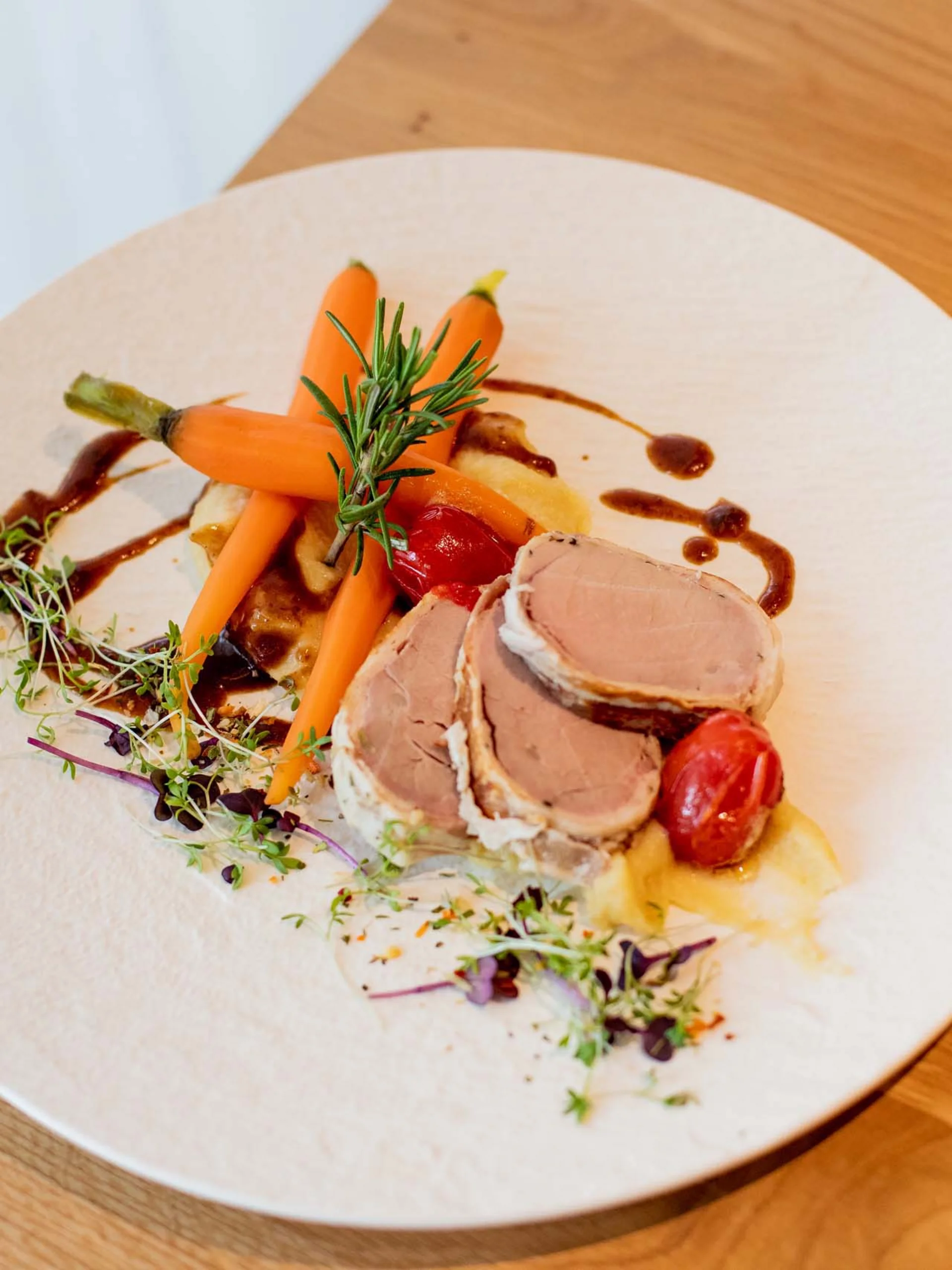 Longevity Urlaub in der Pfalz | Pfalzblick Drei Scheiben Fleisch mit Karotten und Gemüse auf weißem Teller angerichtet
