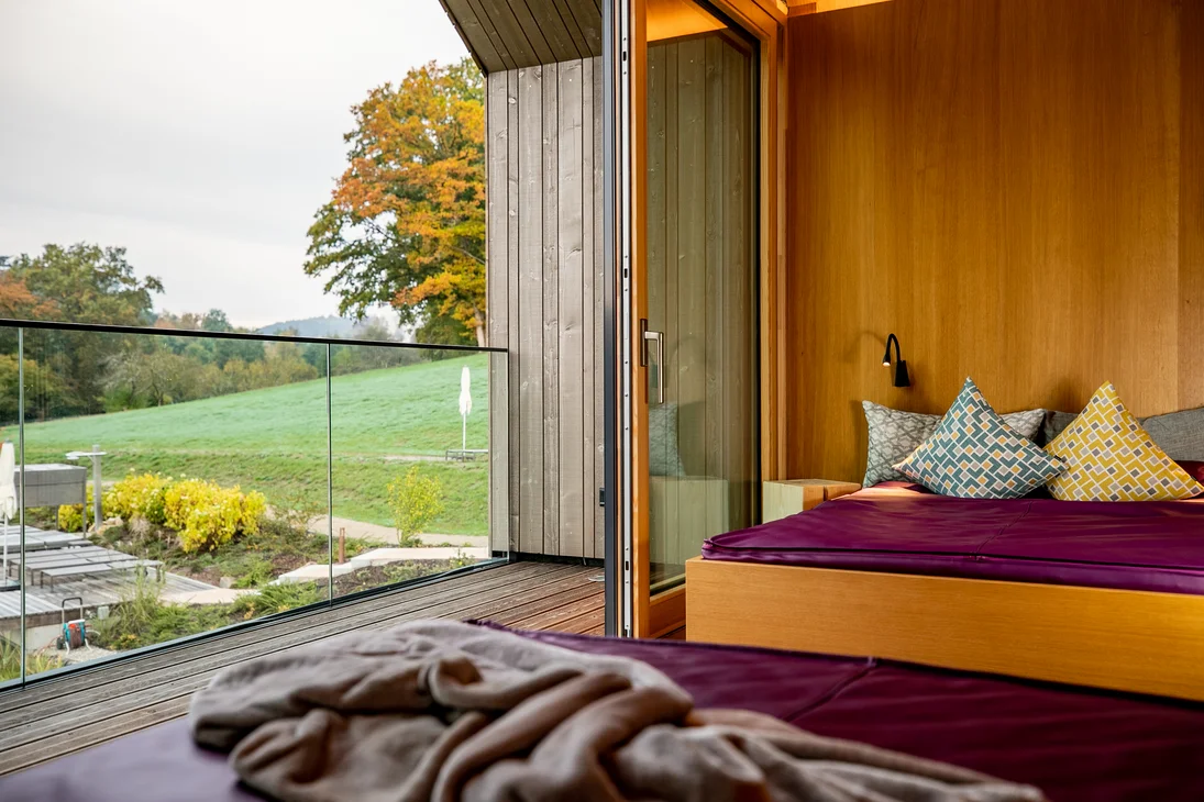Vapeur, senteur, bonheur : sauna sensorielavec vue naturelle Chambre moderne en bois avec vue sur paysage vert en automne