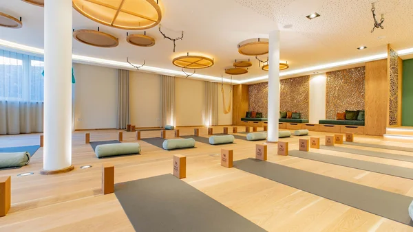 Hell eingerichteter Yoga-Raum mit Matten, Blöcken und Kissen