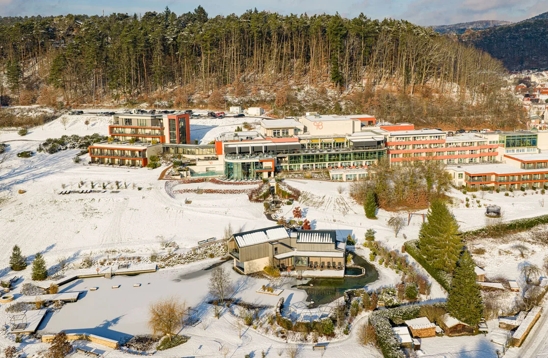 Ihr Hotel im Dahner Felsenland: Pfalzblick Wald Spa Resort Hotel und Wellnessanlage im verschneiten Winterwald aus der Vogelperspektive