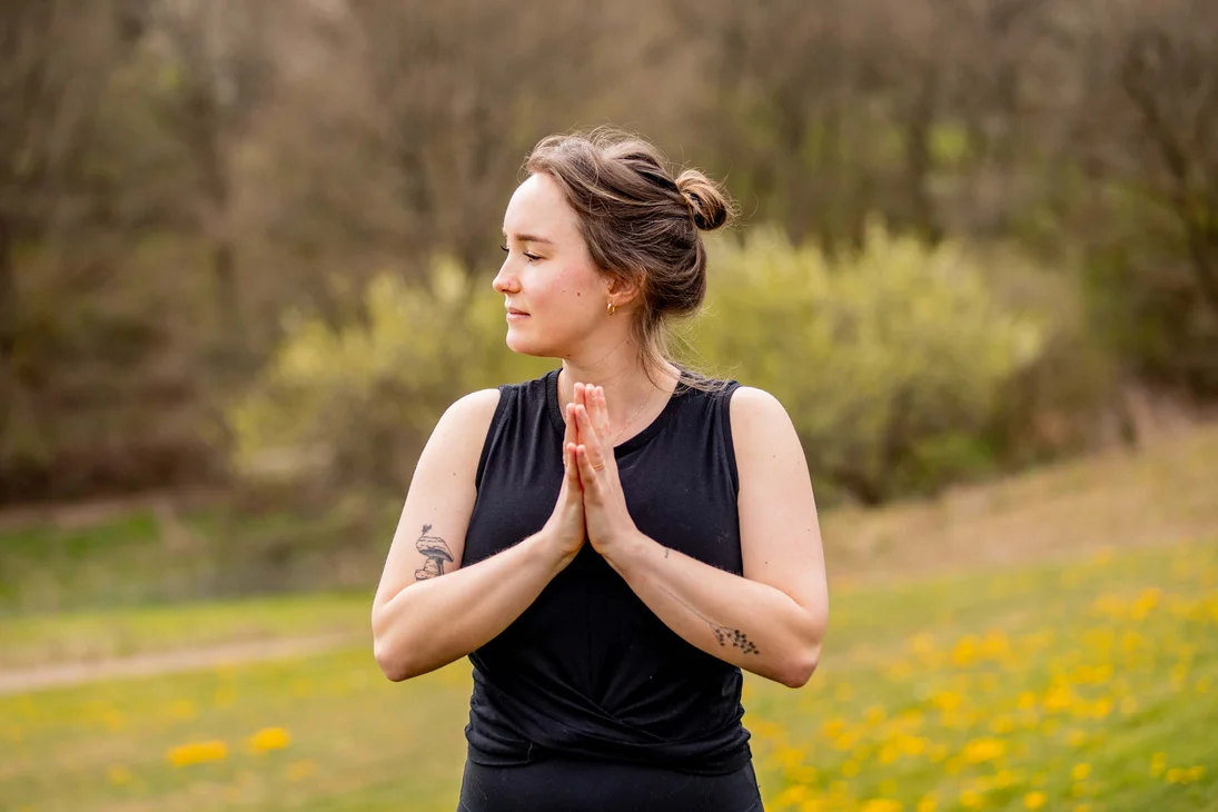 Frau macht Yoga im Freien mit Händen in Gebetshaltung