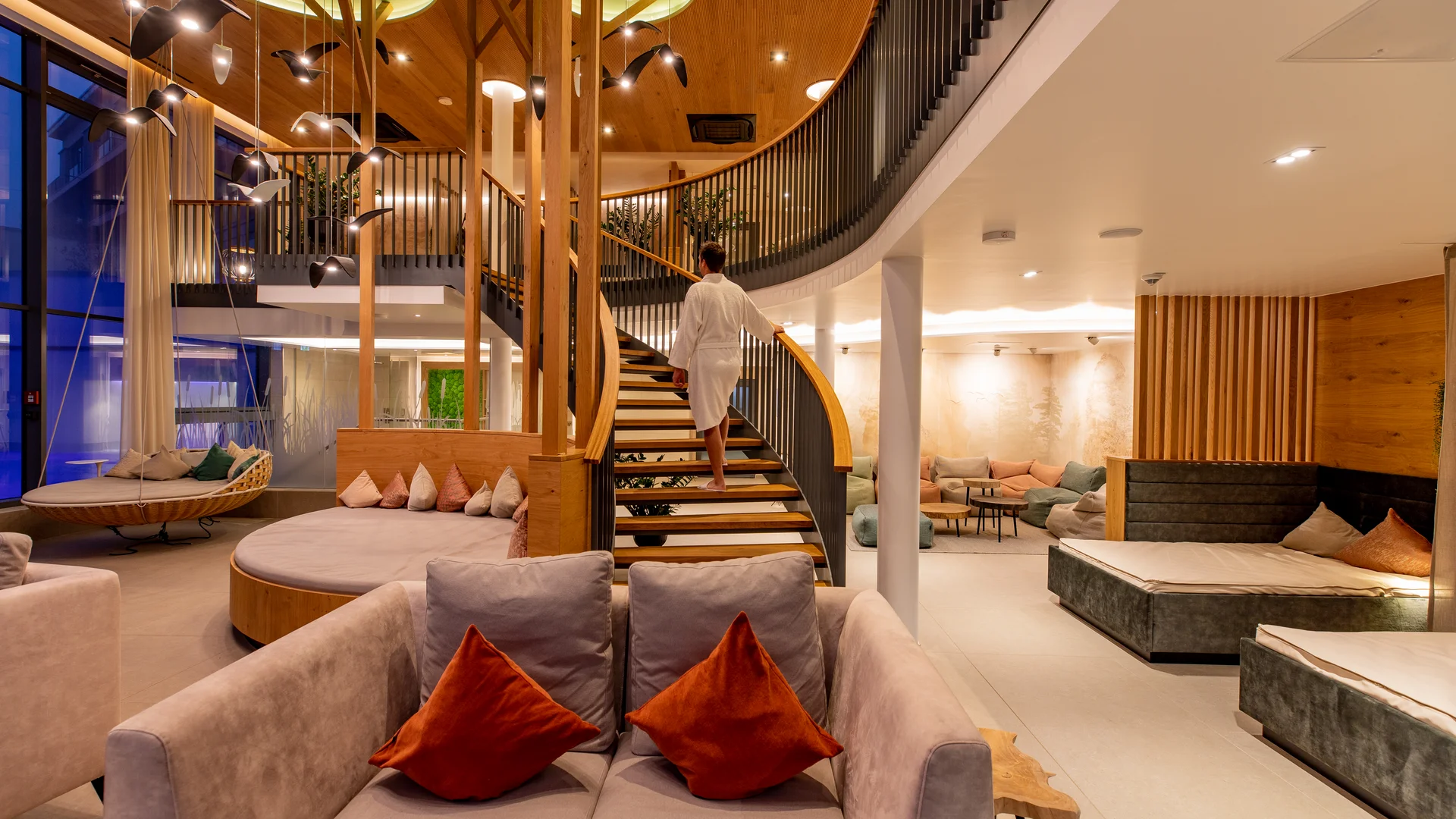 Pressebilder Moderne, gemütliche Lounge mit Treppe und Person in weißem Bademantel