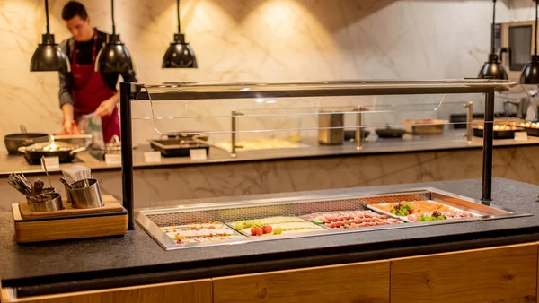 Buffet mit verschiedenen kalten Vorspeisen und Besteck im Gastraum