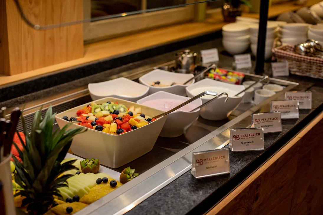 Buffet mit frischem Obstsalat, Joghurt und Quark in weißen Schalen