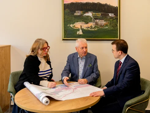 Bau-Blog Drei Personen besprechen einen Plan an einem Tisch