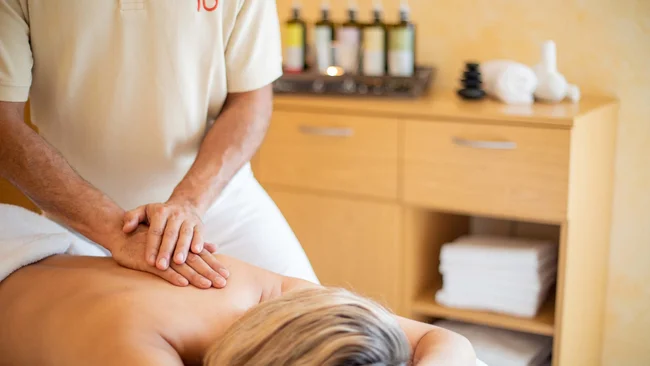 Mann gibt einer Frau eine Rückenmassage in einem Spa-Raum