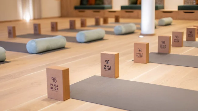 Yoga-Matten mit Blöcken und Zylindern in einem hellen Raum