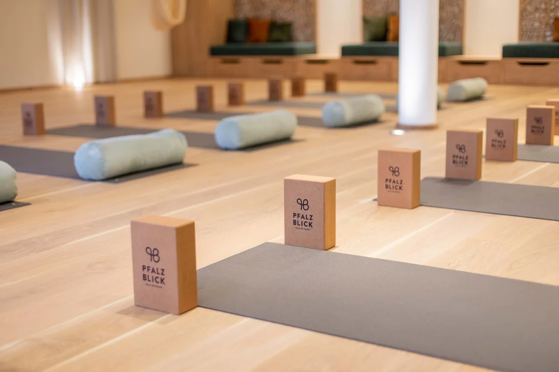 Yoga-Matten mit Blöcken und Zylindern in einem hellen Raum