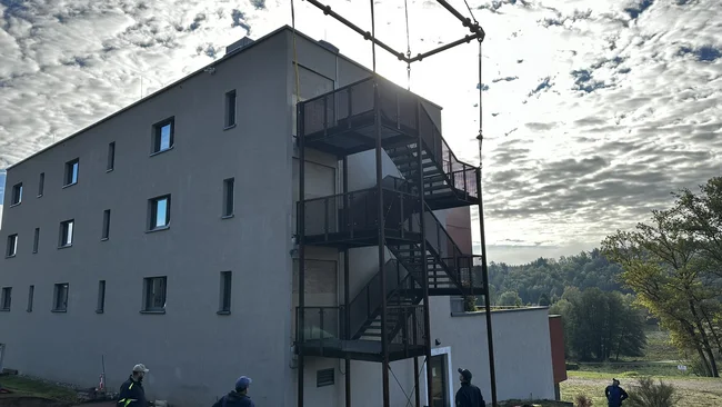 Des ouvriers installent un escalier extérieur sur un bâtiment