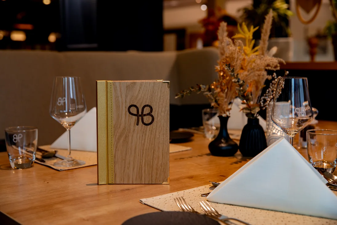 Eleganter Holztisch im Restaurant mit dekorativen Vasen und Menükarten
