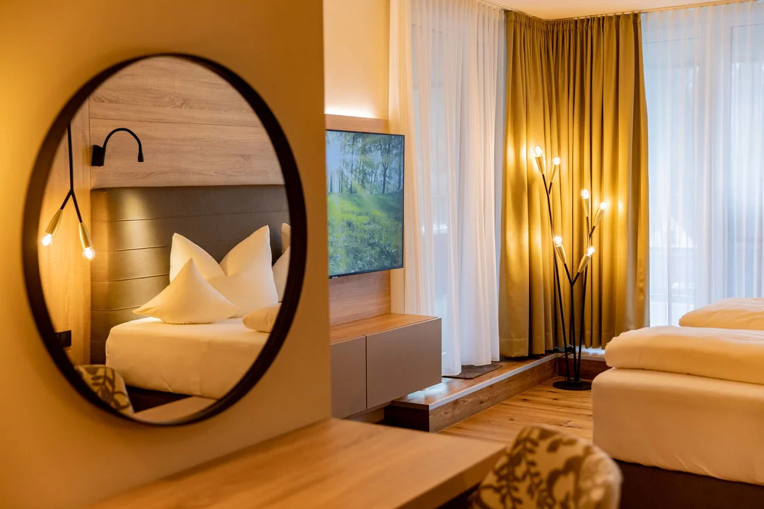 Modernes Hotelzimmer mit Badspiegel, gemütlichem Bett und warmem Licht