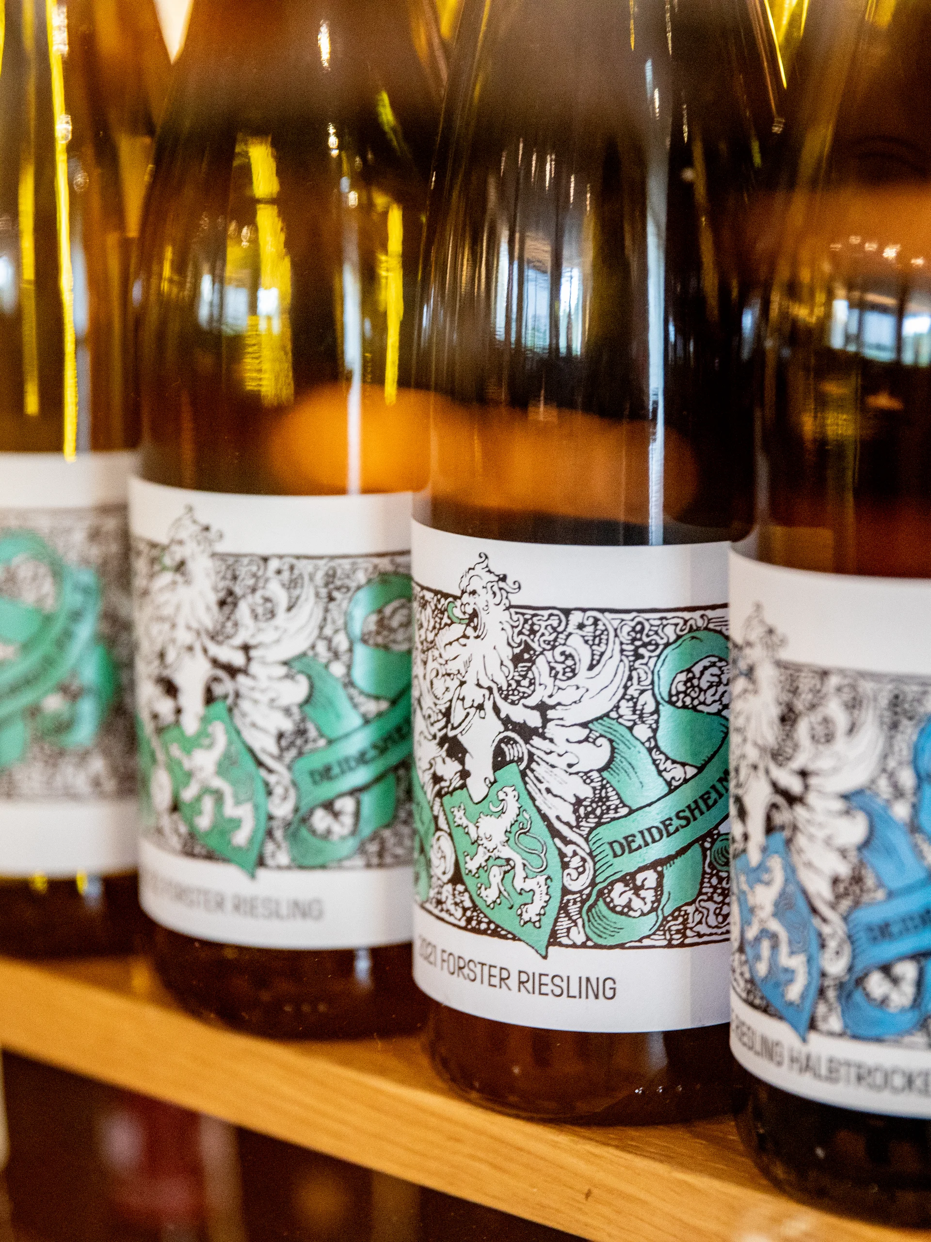 Reihe von Weinflaschen mit detaillierten Etiketten auf einem Holzboden