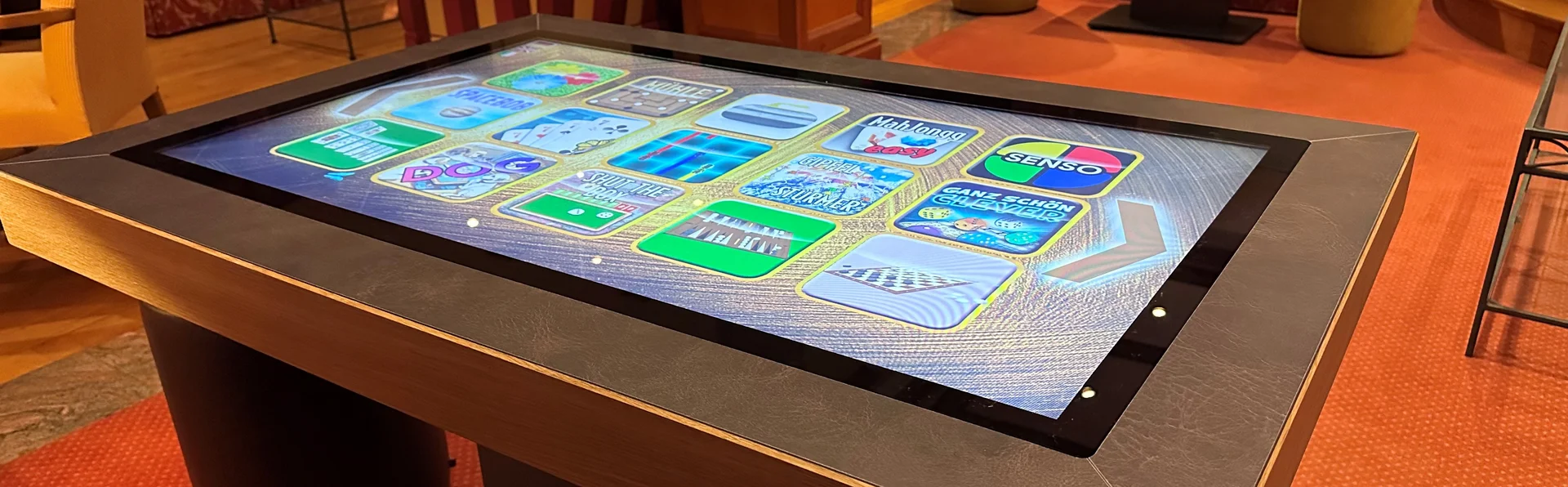 Spaß und Abwechslung für Kinder und Erwachsene! Interaktiver Spieltisch mit digitalen Spielen in gemütlicher Bibliothek