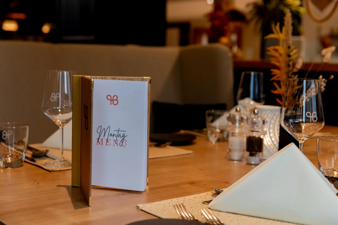 Eleganter gedeckter Tisch mit Montag Menükarte in gemütlichem Restaurant