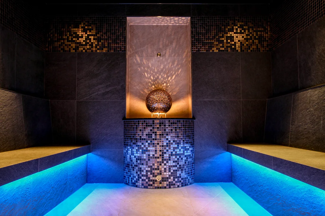 Vapeur, senteur, bonheur : sauna sensorielavec vue naturelle Sauna moderne avec éclairage LED bleu et élément lumineux décoratif au centre